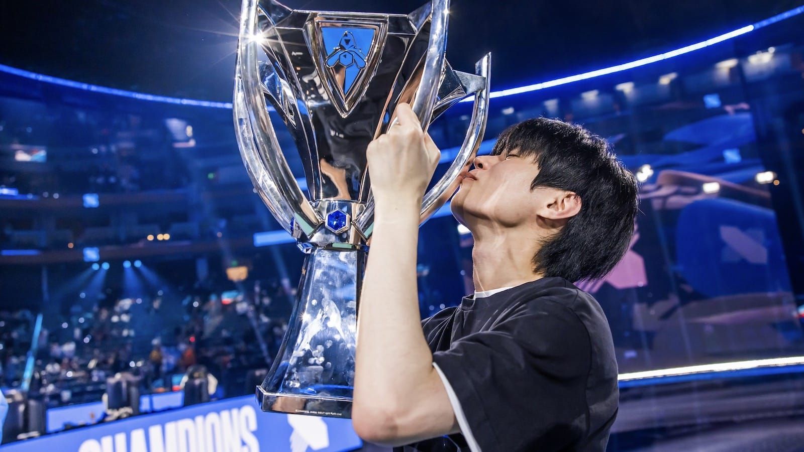 faker holding a trophy from League of Legends worlds